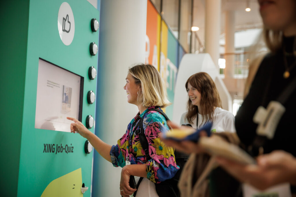 A mood photograph of a young woman enjoying engaging with the game console on a crowded event.